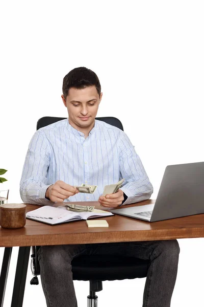 Przystojny Freelancer Człowiek Pracuje Laptopie Trzyma Pieniądze Siedząc Krześle Biurko — Zdjęcie stockowe