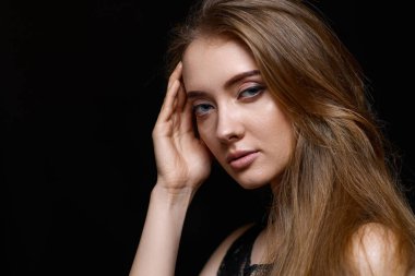 Siyah arka planda siyah elbiseli, uzun saçlı güzel esmer kadın. Boşluğu kopyala