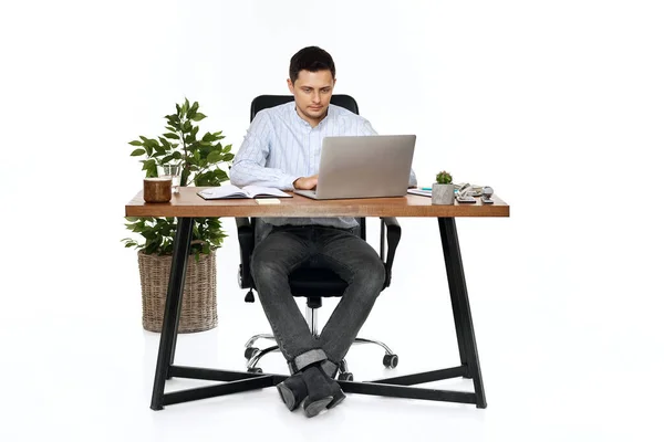 白い背景のテーブルでノートパソコンを使って仕事をしている若者は — ストック写真