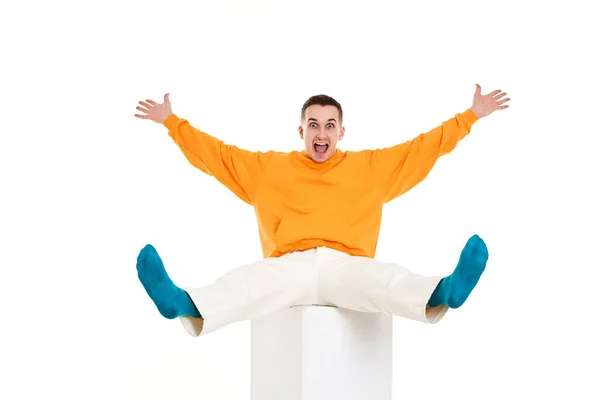 Νεαρός Αστείος Άνδρας Πορτοκαλί Μπλούζα Κάθεται Λευκό Κύβο Λευκό Φόντο — Φωτογραφία Αρχείου