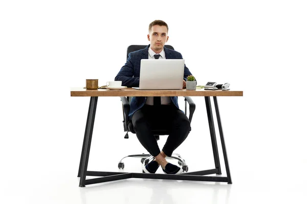 白い背景のテーブルでノートパソコンを使って仕事をしている若者は — ストック写真