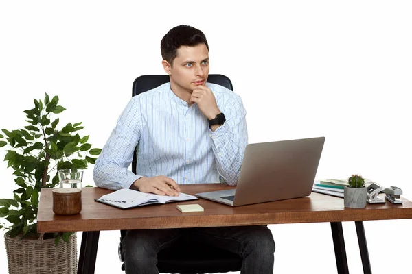 ノートパソコンを使って白い背景のテーブルで仕事をするハンサムな男 — ストック写真