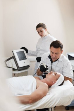 Estetik tıp kliniğinde RF kaldırma prosedüründe yakışıklı bir adam.