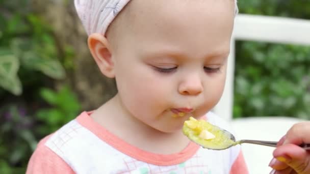 엄마는 여름에 숟가락으로 실외에서 귀여운 국물을 먹인다 — 비디오