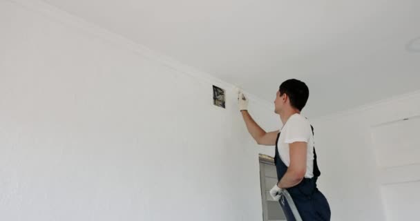 Naprawiający Człowiek Jednolitej Ścianie Malarskiej Kolorze Białym Szczotkami Podczas Renowacji — Wideo stockowe