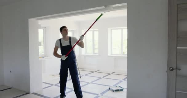 Bauarbeiter Blauen Overalls Streicht Wand Weißer Farbe Mit Walze Während — Stockvideo