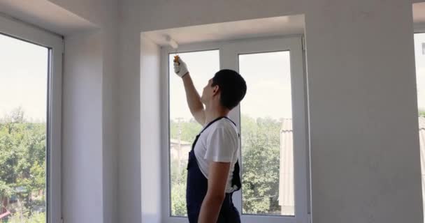 Reparador Macacão Azul Está Pintando Parede Cor Branca Com Rolo — Vídeo de Stock