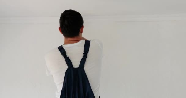 Naprawiający Człowiek Jednolitej Ścianie Malarskiej Kolorze Białym Szczotkami Podczas Renowacji — Wideo stockowe
