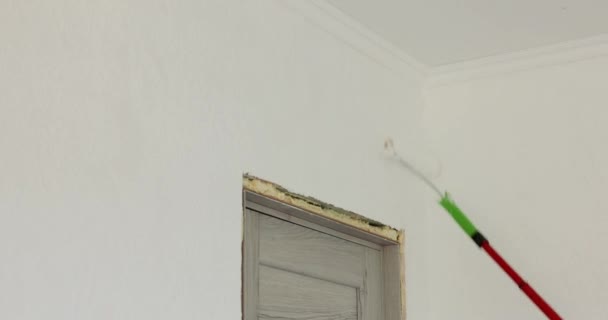 Επιδιορθωτής Άντρας Ζωγραφίζει Τοίχο Λευκό Χρώμα Ρολό Ενώ Ανακαινίζει Δωμάτιο — Αρχείο Βίντεο