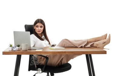 Başarılı iş kadını masadaki online işler için dizüstü bilgisayar kullanıyor.