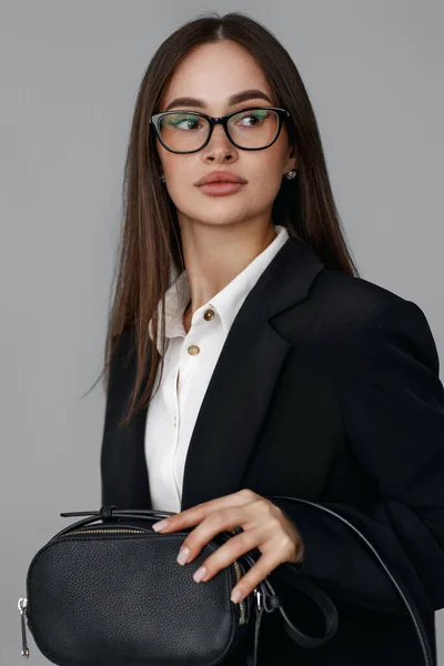 Vacker Kvinna Med Handväska Glasögon Svart Kavaj Isolerad Grå Bakgrund — Stockfoto