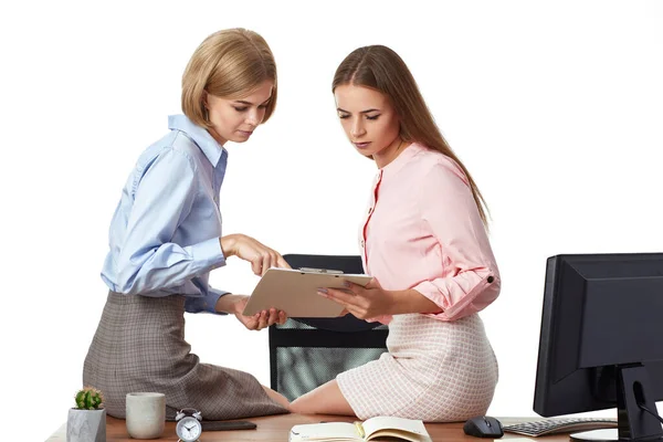 プロジェクトに協力する2人のオフィスの女性労働者 オフィスのクリップボードと机の上に座って — ストック写真