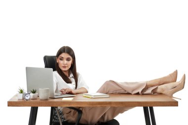 Başarılı iş kadını masadaki online işler için dizüstü bilgisayar kullanıyor.