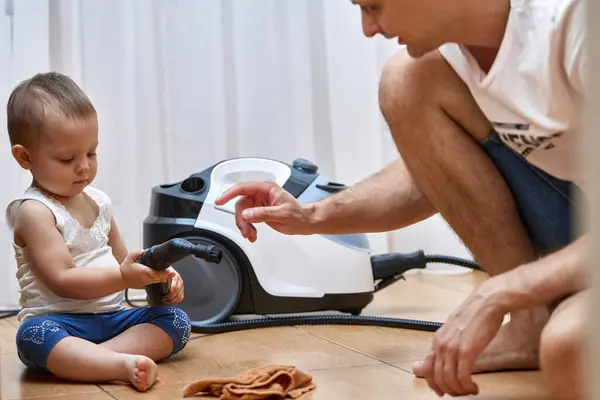 little baby girl helps her dad cleaning with professional cleaning steam generator, cute little helper