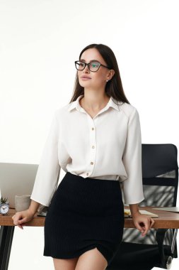 Ofisteki masada çalışan genç ve güzel bir iş kadını..