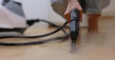Kadın eli profesyonel temizlik buhar jeneratörüyle mutfakta döşeme temizliği, ev dezenfeksiyonu.