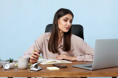 Moda işkadını masadaki online işler için dizüstü bilgisayar kullanıyor.