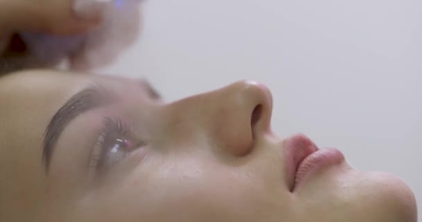 サロンのまつげ延長プロシージャのためのプライマー スプレーを使用する化粧品学者 — ストック動画