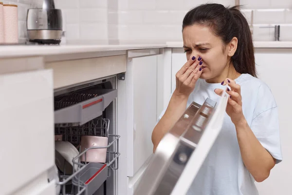 Kvinna Luktar Konstigt Och Fruktansvärt Lukt Som Kommer Från Diskmaskin — Stockfoto