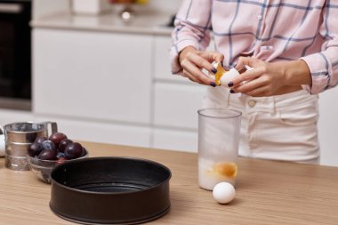 Modern mutfakta pişirmek için yumurta kıran kadın elleri