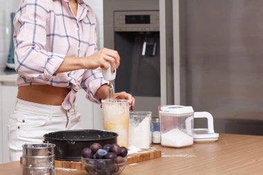 Modern mutfakta hamuru turta için karıştıran kadın.