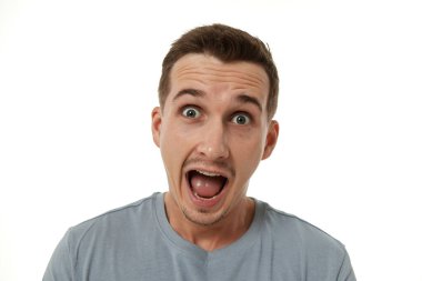 Beyaz stüdyo arka planında kameraya bakan şaşırmış bir adam.