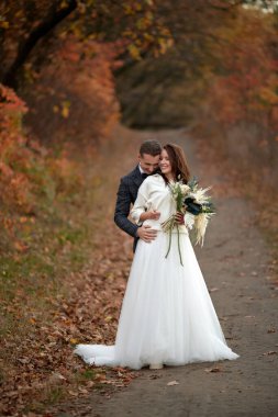 Beyaz gelinlik içinde güzel, şehvetli gelin ve damat dışarıda bekliyor.