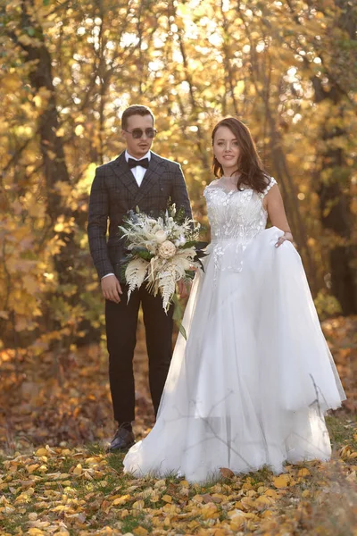 穿着白色婚纱的漂亮性感新娘和自然背景站在户外的新郎 — 图库照片