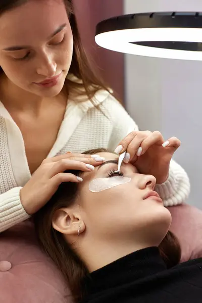 美容师用镊子为美容院的年轻女性做睫毛伸展 — 图库照片