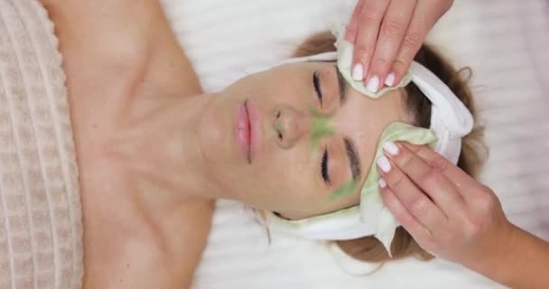Schoonheidsspecialiste Reinigt Vrouwelijke Huid Met Servet Groen Kleimasker Perfecte Reiniging — Stockvideo