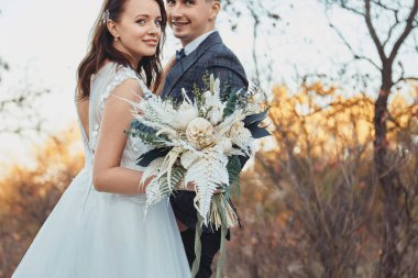 Gelin ve damat düğün günü güzel bir buket tutuyorlar..