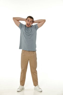 Beyaz stüdyo arka planında kameraya bakan şaşırmış bir adam.