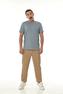 Beyaz stüdyo arka planında kameraya bakan şaşırmış bir adam.