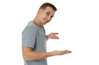 Mutlu adam beyaz stüdyo arka planındaki fotokopi alanını işaret ediyor.