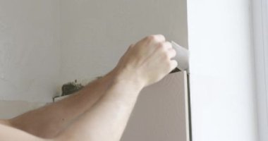Erkek usta duvara seramik fayanslar yapıştırıyor. Mutfağa beyaz fayanslar seriyorum.