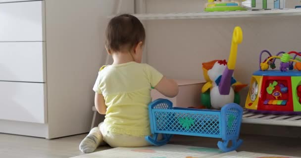 Niedliches Baby Mädchen Spielt Mit Spielzeug Während Auf Dem Boden — Stockvideo