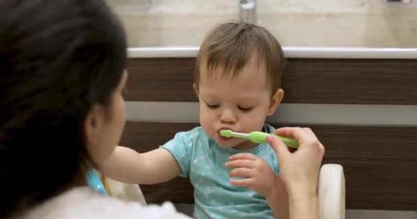 妈妈教女婴用牙刷刷牙 妈妈在浴室里刷牙 — 图库视频影像