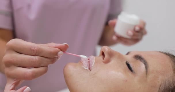 Esteticista Aplica Crema Anestésica Los Labios Femeninos Antes Inyectar Ácido — Vídeo de stock