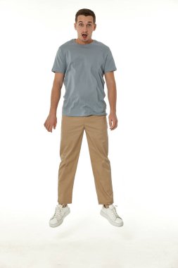 Beyaz stüdyo arka planında kameraya bakan şaşırmış bir adam.