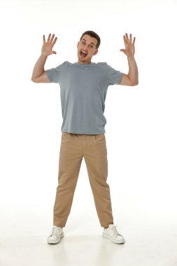 Beyaz stüdyo arka planında kameraya bakan şaşırmış bir adam.