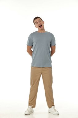 Beyaz stüdyo arka planında kameraya bakan şaşırmış bir adam.