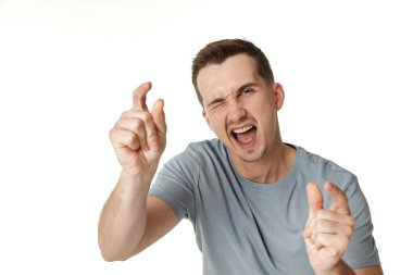 Genç mutlu bir adamın beyaz arka plandaki kameraya göz kırpan portresi.