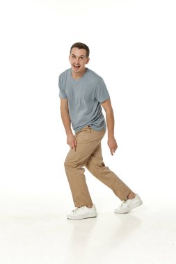 Beyaz stüdyo arka planında kameraya bakan şaşırmış bir adam.