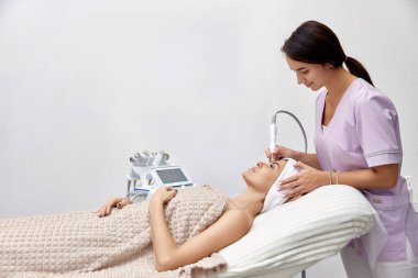 Güzellik salonunda kadın müşteri için kozmetik uzmanı soyma işlemi yapıyor.