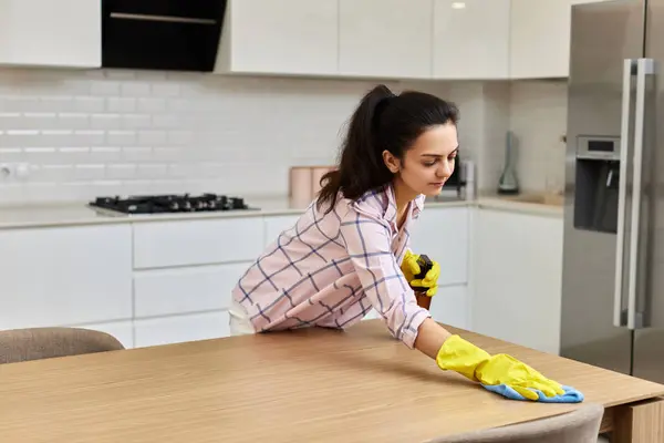 若い女性はマイクロファイバー布で木製のテーブルを掃除し拭きます 自宅でチャールズ ハウスキーピング — ストック写真