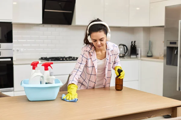 手袋の若い女性 クリーニングとマイクロファイバーの布で木製のテーブルを拭きます 自宅でチャールズ ハウスキーピング — ストック写真