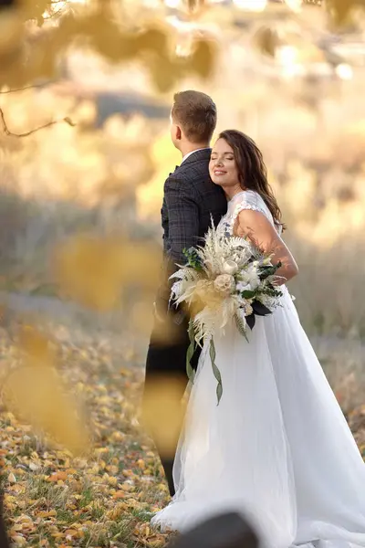 Красивая Чувственная Невеста Белом Свадебном Платье Держа Букет Обнимая Жениха — стоковое фото