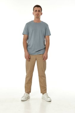 Beyaz arka planda hayal kırıklığına uğramış genç bir adam. Üzüntü