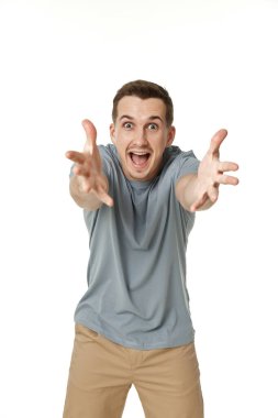 Mutlu adam beyaz stüdyo arka planında kamerayı işaret ediyor.