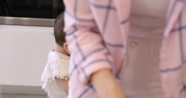 キッチンで調理するお母さんを助ける小さな子供の娘 — ストック動画